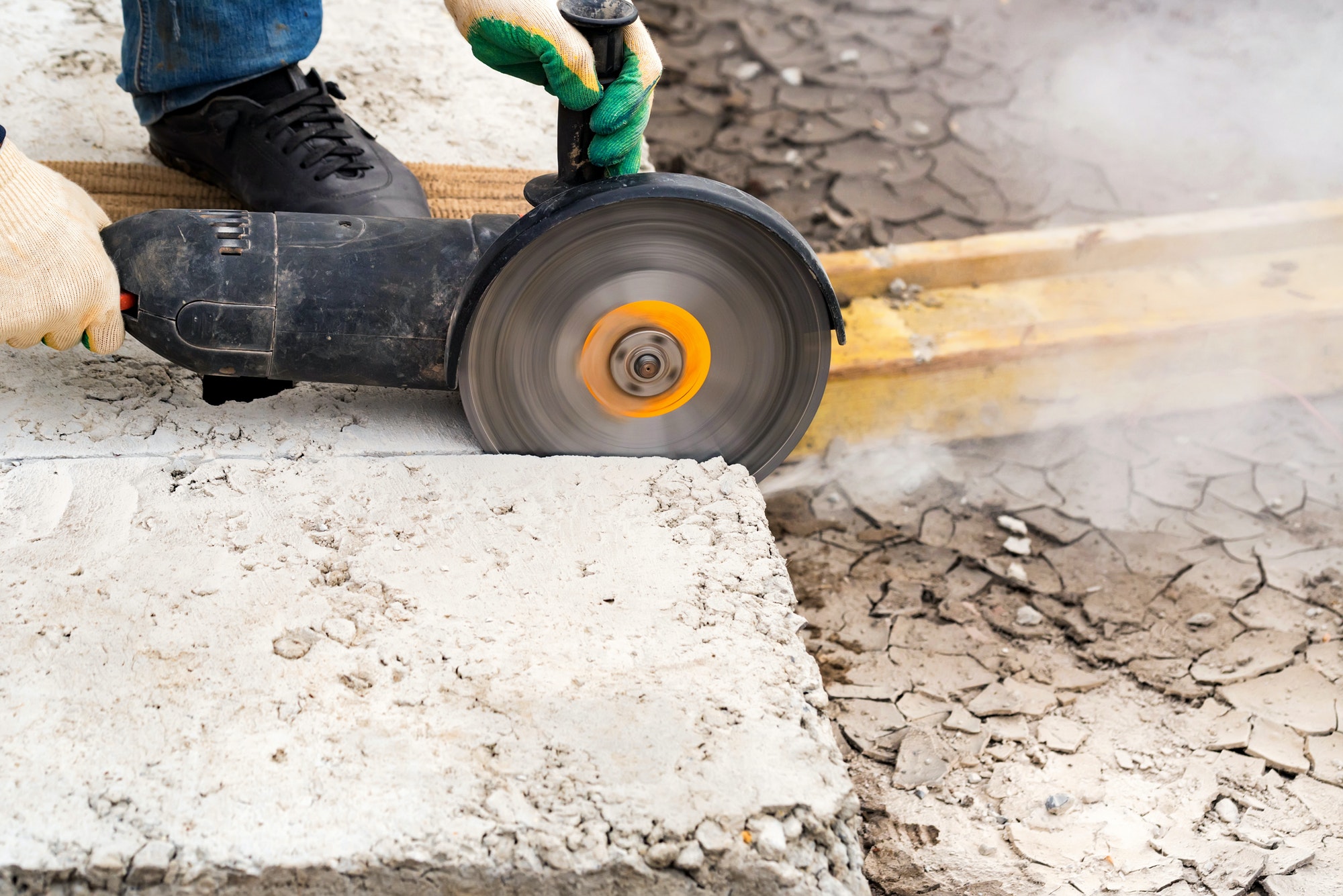 Close up worker cuts concrete with circular saw